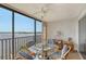 Glass-top table and chairs on a lanai overlooking the water at 8911 Midnight Pass Rd # 410, Sarasota, FL 34242