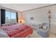 Cozy bedroom with a red comforter, a grey chair, and a view at 8911 Midnight Pass Rd # 410, Sarasota, FL 34242
