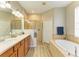 Elegant bathroom with double sinks, a soaking tub, and a walk-in shower at 350 River Enclave Ct, Bradenton, FL 34212