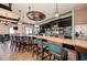 Modern bar with granite countertops, teal bar stools, and multiple screens at 350 River Enclave Ct, Bradenton, FL 34212