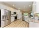 Modern kitchen with stainless steel appliances, white cabinetry, and light wood flooring at 350 River Enclave Ct, Bradenton, FL 34212