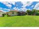Large backyard with lush green grass and a screened patio at 350 River Enclave Ct, Bradenton, FL 34212