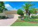 Tan house with lush landscaping and a brick paved driveway at 350 River Enclave Ct, Bradenton, FL 34212