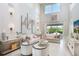 Spacious living room with high ceilings, neutral decor, and access to a patio at 15025 Shady Palms Ln, Nokomis, FL 34275