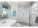 Bathroom with white vanity, white and gray herringbone tile shower at 15076 Shady Palms Ln, Nokomis, FL 34275