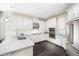 Modern kitchen with white cabinets, quartz countertops, and stainless steel appliances at 15076 Shady Palms Ln, Nokomis, FL 34275