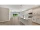 Open kitchen with white cabinets, island, and sliding glass doors leading to backyard at 14551 Skipping Stone Loop, Parrish, FL 34219