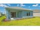 Backyard view of charming home with sliding glass doors leading to patio at 14551 Skipping Stone Loop, Parrish, FL 34219