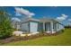 Single-story home with light blue siding, two-car garage, and covered porch at 14551 Skipping Stone Loop, Parrish, FL 34219