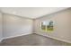 Bright bedroom with gray walls, wood-look tile flooring, and a window at 14551 Skipping Stone Loop, Parrish, FL 34219