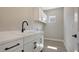 Laundry room with white cabinets, black hardware, and quartz countertops at 14551 Skipping Stone Loop, Parrish, FL 34219