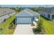 Single-story home with light blue exterior, two-car garage, and landscaped yard at 14551 Skipping Stone Loop, Parrish, FL 34219