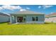 Backyard view of charming home with sliding glass doors leading to patio at 14551 Skipping Stone Loop, Parrish, FL 34219