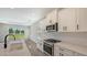 Bright kitchen boasts white cabinets, quartz countertops, and stainless steel appliances at 14551 Skipping Stone Loop, Parrish, FL 34219