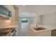 Modern kitchen with white cabinets, island, and view into the living area at 14705 Barefoot Ln, Parrish, FL 34219