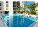 Inviting community pool with surrounding lounge chairs and patio tables at 6157 Midnight Pass Rd # G11, Sarasota, FL 34242