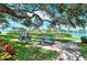 Relaxing waterfront picnic area with benches under a large oak tree at 6157 Midnight Pass Rd # G11, Sarasota, FL 34242