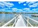 Long white dock extending over calm water towards waterfront homes at 6157 Midnight Pass Rd # G11, Sarasota, FL 34242