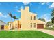 Front view of a two-story yellow house with a grassy lawn and palm trees at 6515 Mauna Loa Blvd, Sarasota, FL 34241