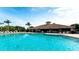 Resort-style pool and lounge area with bar and lush tropical landscaping under clear blue sky at 1003 Fairwaycove Ln # 205, Bradenton, FL 34212