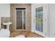 Bathroom featuring tiled walk-in shower, pedestal sink, hardwood floors and outdoor access at 3125 Pickett St, Port Charlotte, FL 33981