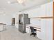 Bright kitchen with white cabinetry, stainless steel refrigerator, and built-in desk area at 3125 Pickett St, Port Charlotte, FL 33981