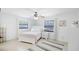 Bright bedroom with white furniture, ceiling fan, patterned rug, and view of pool at 4175 Arrow Ln, Sarasota, FL 34232