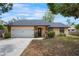 Charming single Gathering home featuring a white garage door, stone accents, and a well-maintained yard at 4175 Arrow Ln, Sarasota, FL 34232