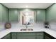 Bright kitchen showcasing stylish green cabinets, white countertops, and modern fixtures at 4175 Arrow Ln, Sarasota, FL 34232