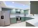 Well-lit kitchen featuring green cabinets, stainless steel appliances, and a stylish white backsplash at 4175 Arrow Ln, Sarasota, FL 34232