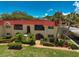 Condo building with red tile roof and lush landscaping at 213 Rubens Dr # D, Nokomis, FL 34275