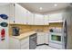 Updated kitchen with white cabinets, stainless steel appliances, and corner sink at 213 Rubens Dr # D, Nokomis, FL 34275