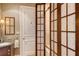 Bathroom with a bathtub and shower behind shoji screens at 2151 Gulf Of Mexico Dr # 5, Longboat Key, FL 34228