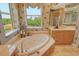 Spa-like bathroom featuring a large soaking tub and views at 2151 Gulf Of Mexico Dr # 5, Longboat Key, FL 34228