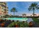 Relaxing pool area with lush landscaping, building in background, and sunset views at 2151 Gulf Of Mexico Dr # 5, Longboat Key, FL 34228
