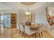 Bright dining room with hardwood floors, wooden table, and adjacent kitchen at 2151 Gulf Of Mexico Dr # 5, Longboat Key, FL 34228
