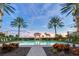 Inviting resort-style pool with a gazebo, lush landscaping, and ocean views at sunset at 2151 Gulf Of Mexico Dr # 5, Longboat Key, FL 34228