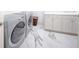 Laundry room with front load washer and dryer, marble floor and cabinets at 1111 Ritz Carlton Dr # 1802, Sarasota, FL 34236