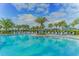 Expansive community pool with lounge chairs and palm trees at 14631 Barefoot Ln, Parrish, FL 34219