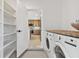 Bright laundry room with washer, dryer, and view into the kitchen at 301 Aurora E St, Venice, FL 34285