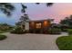 Modern cottage at dusk with lighted window and gravel driveway at 301 Aurora E St, Venice, FL 34285
