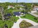 Aerial view showcasing a renovated home, landscaped yard, and circular driveway at 301 Aurora E St, Venice, FL 34285
