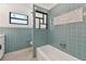 Updated bathroom with blue tile, new tub and shower, and a modern design at 301 Aurora E St, Venice, FL 34285