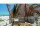 Exterior view of a beautiful beach house, showcasing the waterfront access and beach at 107 Elm Ave, Anna Maria, FL 34216