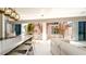 Open living room with island and floor to ceiling windows leading to an outdoor patio and beach at 107 Elm Ave, Anna Maria, FL 34216