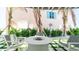 Cozy outdoor patio area featuring comfortable seating around a modern fire pit, surrounded by lush landscaping at 107 Elm Ave, Anna Maria, FL 34216