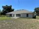 A spacious backyard with a well-maintained lawn, a concrete patio, and a clear view of the house's rear exterior at 4012 Oscar Ter, North Port, FL 34286