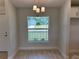 A compact dining room features a modern chandelier, neutral walls, and tile flooring at 4012 Oscar Ter, North Port, FL 34286