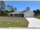 Charming single-story home featuring a two-car garage, a welcoming front porch, and a well-maintained lawn at 4012 Oscar Ter, North Port, FL 34286