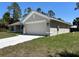 A side view of a well-maintained home featuring a two-car garage and a concrete driveway at 4012 Oscar Ter, North Port, FL 34286